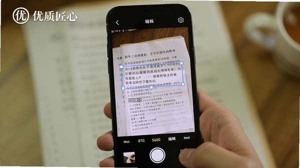 优质匠心软件中的文字识别功能演示,手机摄像头对准纸质文档,屏幕上实时框选文字并转换为可编辑文本,界面带有优质匠心的logo标识