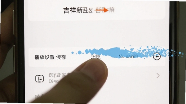 吉祥新闻APP在手机上的设置界面截图,画面中手指正在点击“播放设置”选项,背景为简洁的白色界面,突出操作指引