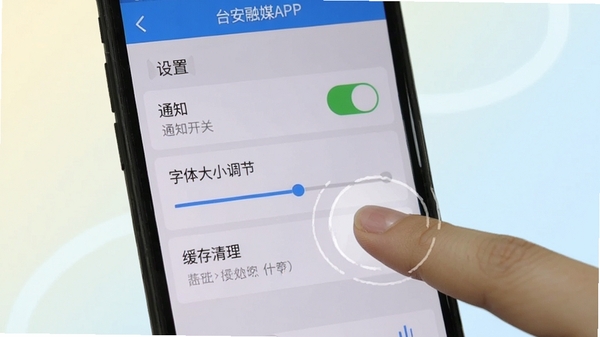台安融媒APP移动端操作界面截图,展示设置页面中通知开关、字体大小调节、缓存清理等选项,手机屏幕外有手指点击操作示意,背景为浅色渐变,突出使用教程氛围